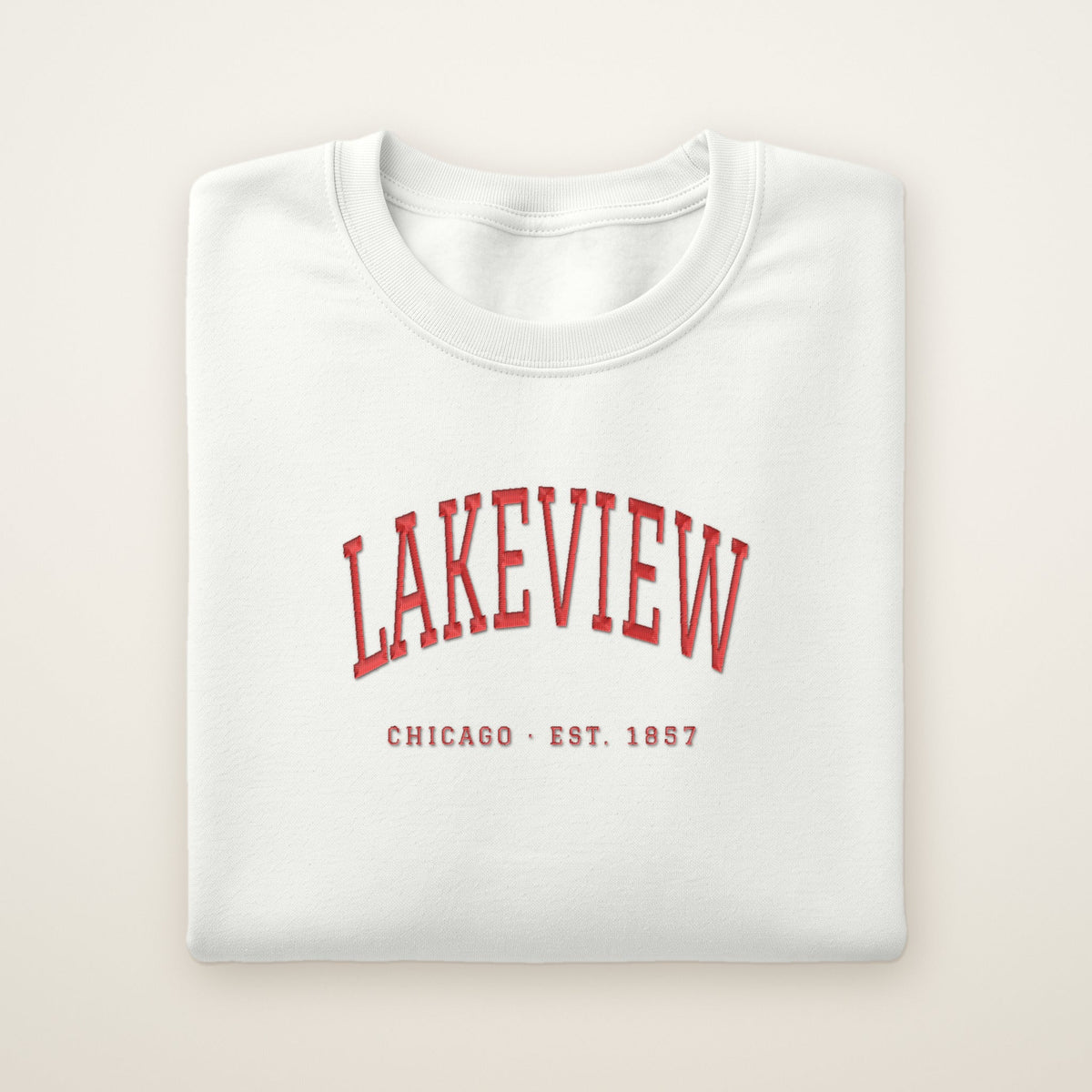 White Lakeview Chicago embroidered crewneck with red thread, folded on ivory