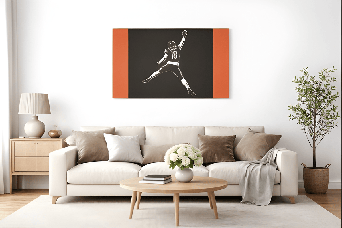Caleb Williams navy and orange silhouette canvas above a white sofa in a living room
