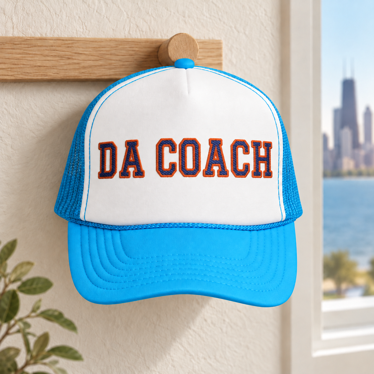 Da Coach embroidered foam trucker hat in white and light blue on a wall hook