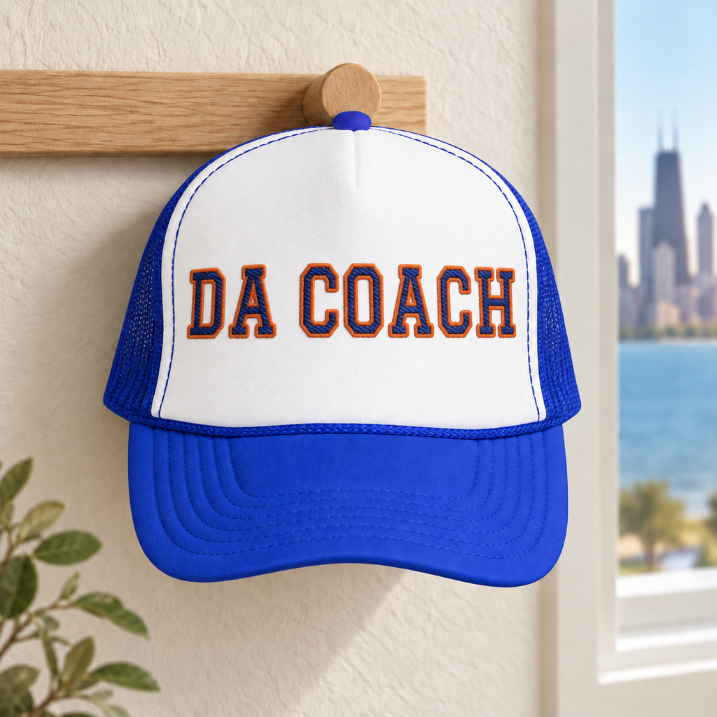 Da Coach embroidered foam trucker hat in white and royal blue on a wall hook