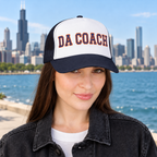 Woman wearing the Da Coach embroidered foam trucker hat in white and navy on the Chicago lakefront