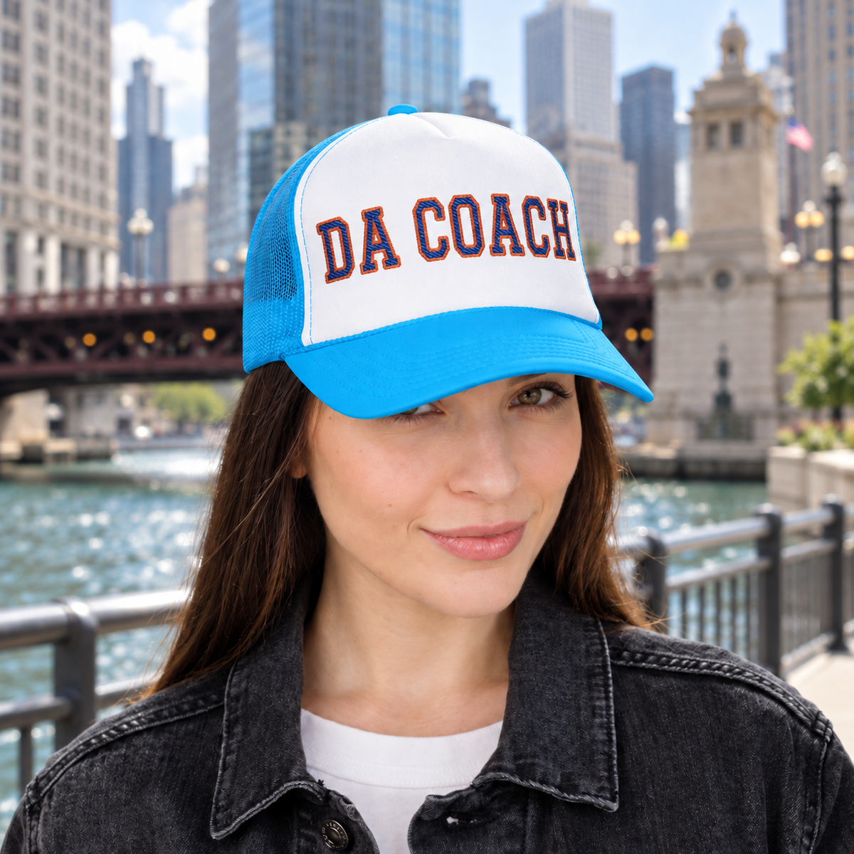 Woman wearing the Da Coach embroidered foam trucker hat in white and light blue on the Chicago Riverwalk