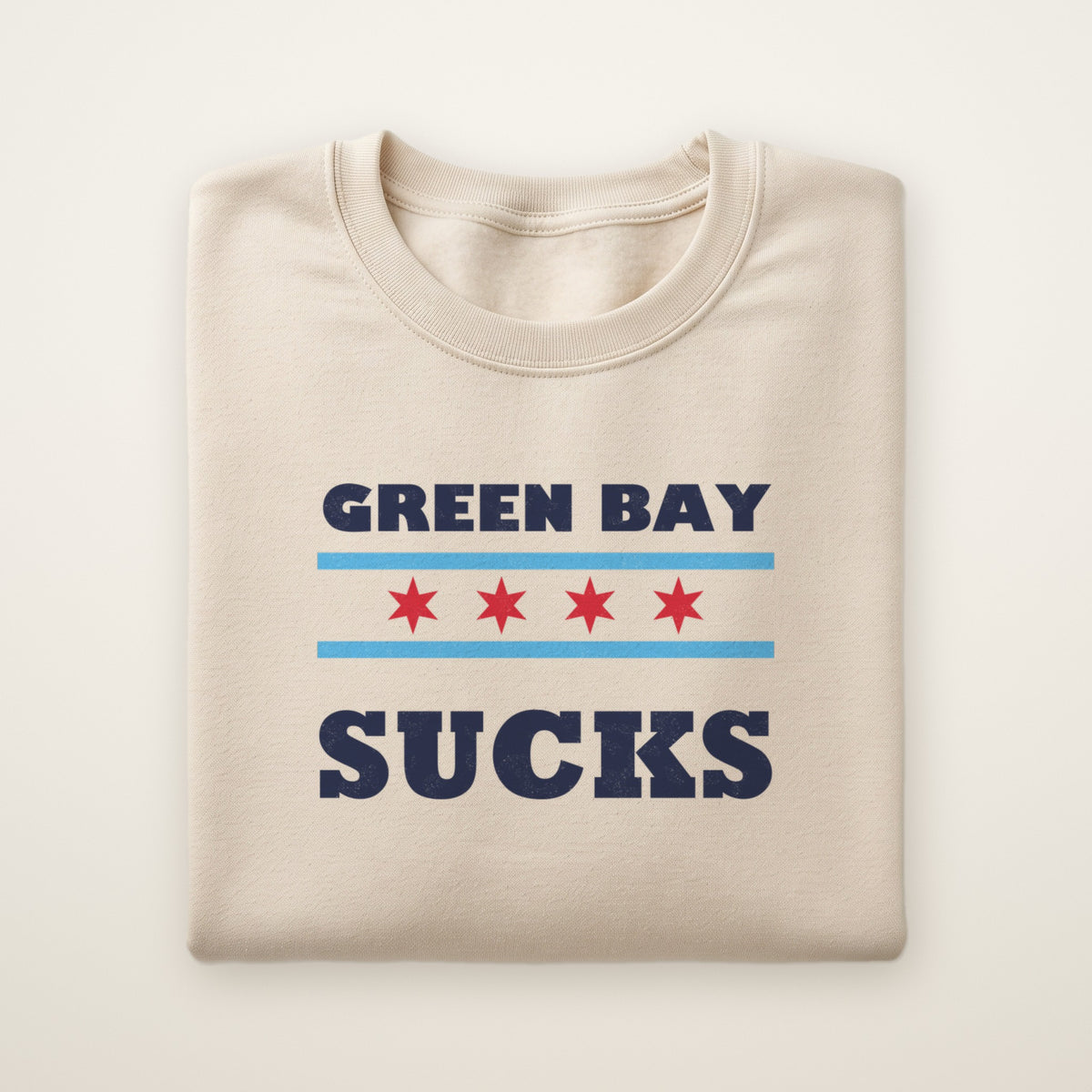 Green Bay Sucks Chicago Flag crewneck in Sand, flat lay with Chicago flag stars between the words