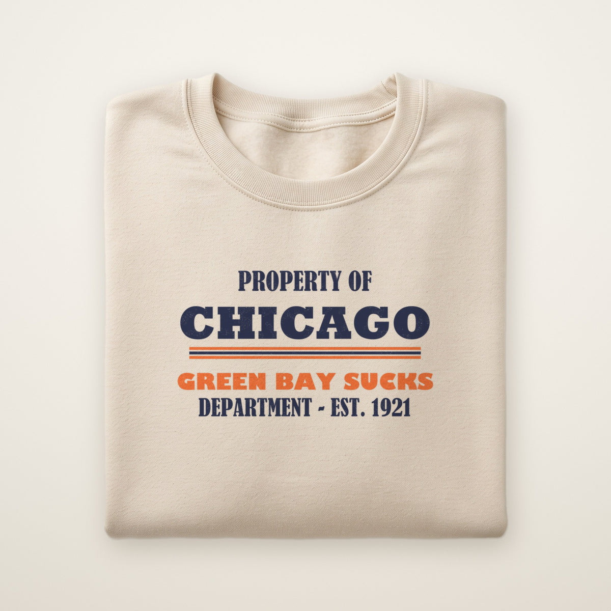 Property of Chicago Green Bay Sucks Dept. crewneck in Sand, flat lay with navy and orange print