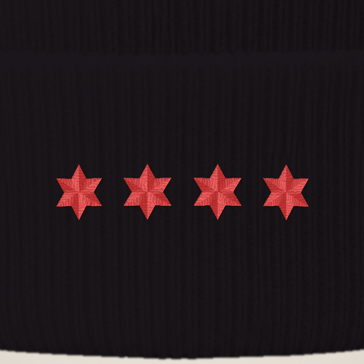 Close-up of four red embroidered six-point stars on the beanie cuff