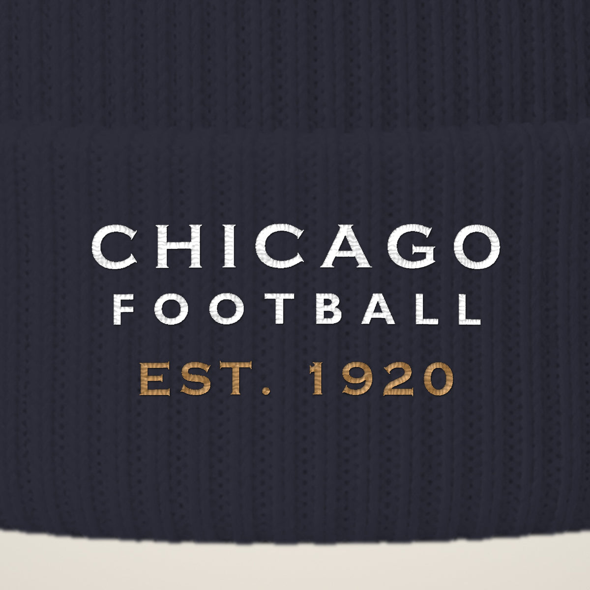 Close-up of CHICAGO FOOTBALL EST. 1920 embroidery on the pom-pom beanie cuff