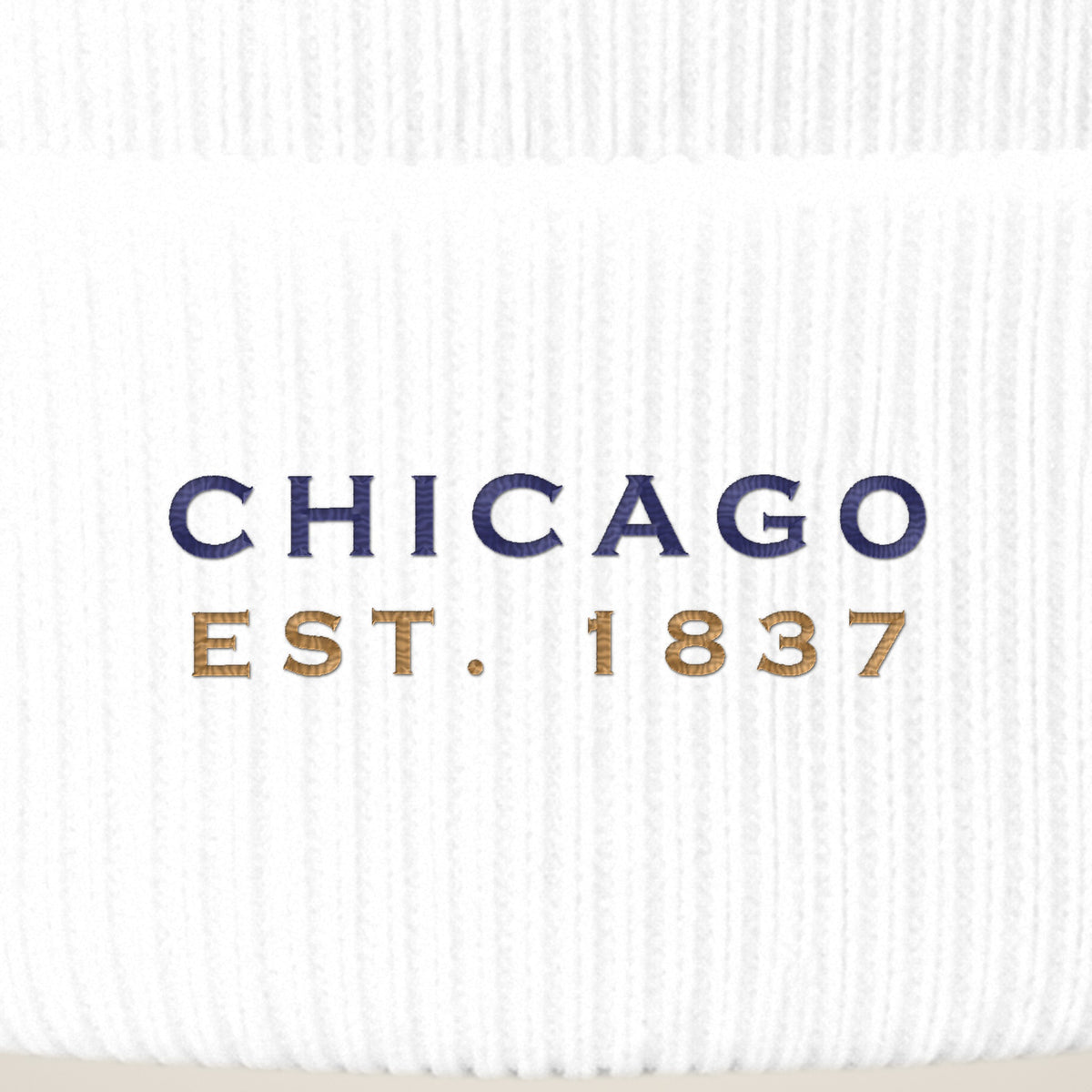Close-up of navy CHICAGO EST. 1837 embroidery on a white beanie cuff