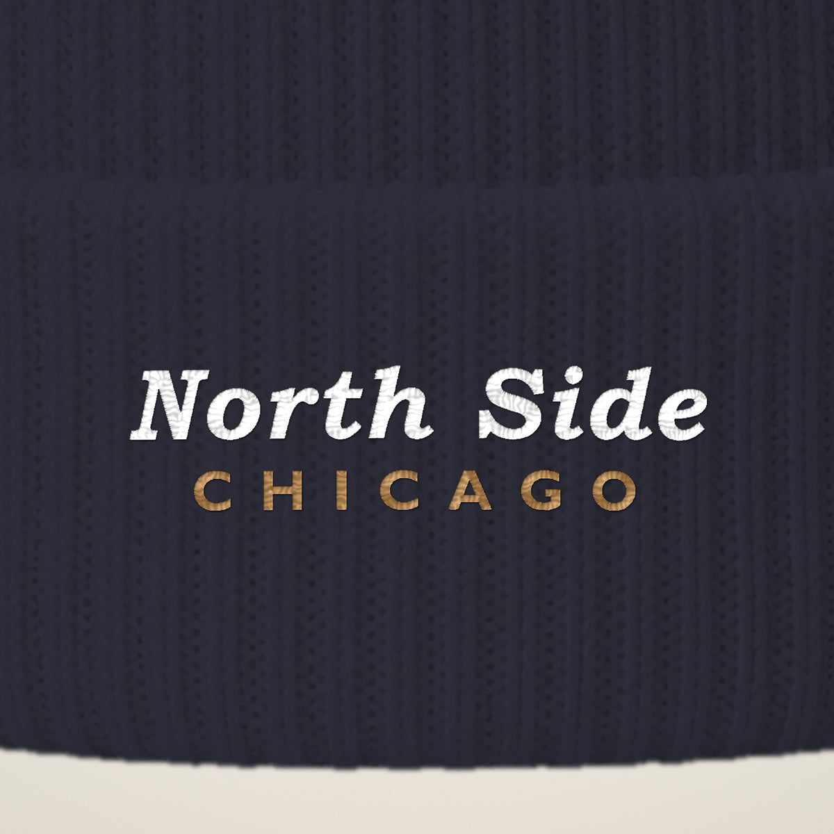 Close-up of North Side Chicago embroidery on the pom-pom beanie cuff