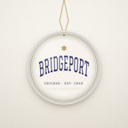 Bridgeport Chicago Christmas Ornament, Est. 1836 hanging on a gold cord, ivory backdrop