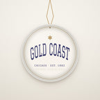 Gold Coast Chicago Christmas Ornament, Est. 1882 hanging on a gold cord, ivory backdrop