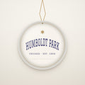Humboldt Park Chicago Christmas Ornament, Est. 1869 hanging on a gold cord, ivory backdrop