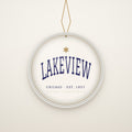 Lakeview Chicago Christmas Ornament, Est. 1857 hanging on a gold cord, ivory backdrop
