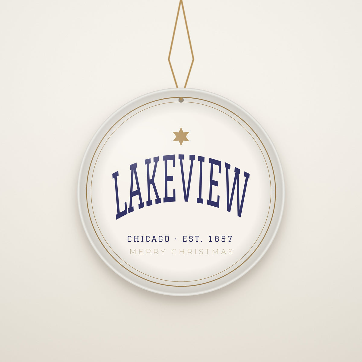 Lakeview Chicago Christmas Ornament, Est. 1857 hanging on a gold cord, ivory backdrop
