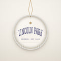 Lincoln Park Chicago Christmas Ornament, Est. 1865 hanging on a gold cord, ivory backdrop