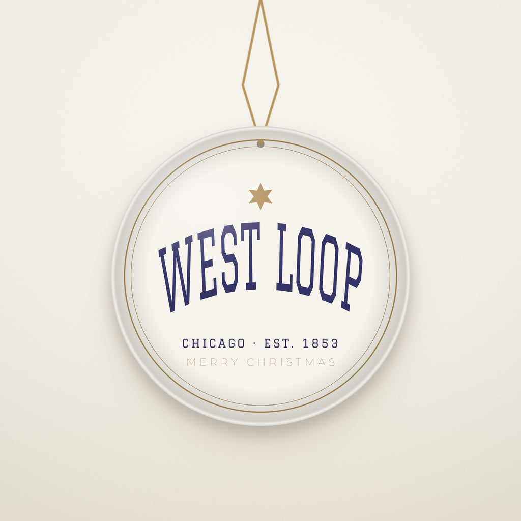 West Loop Chicago Christmas Ornament, Est. 1853 hanging on a gold cord, ivory backdrop