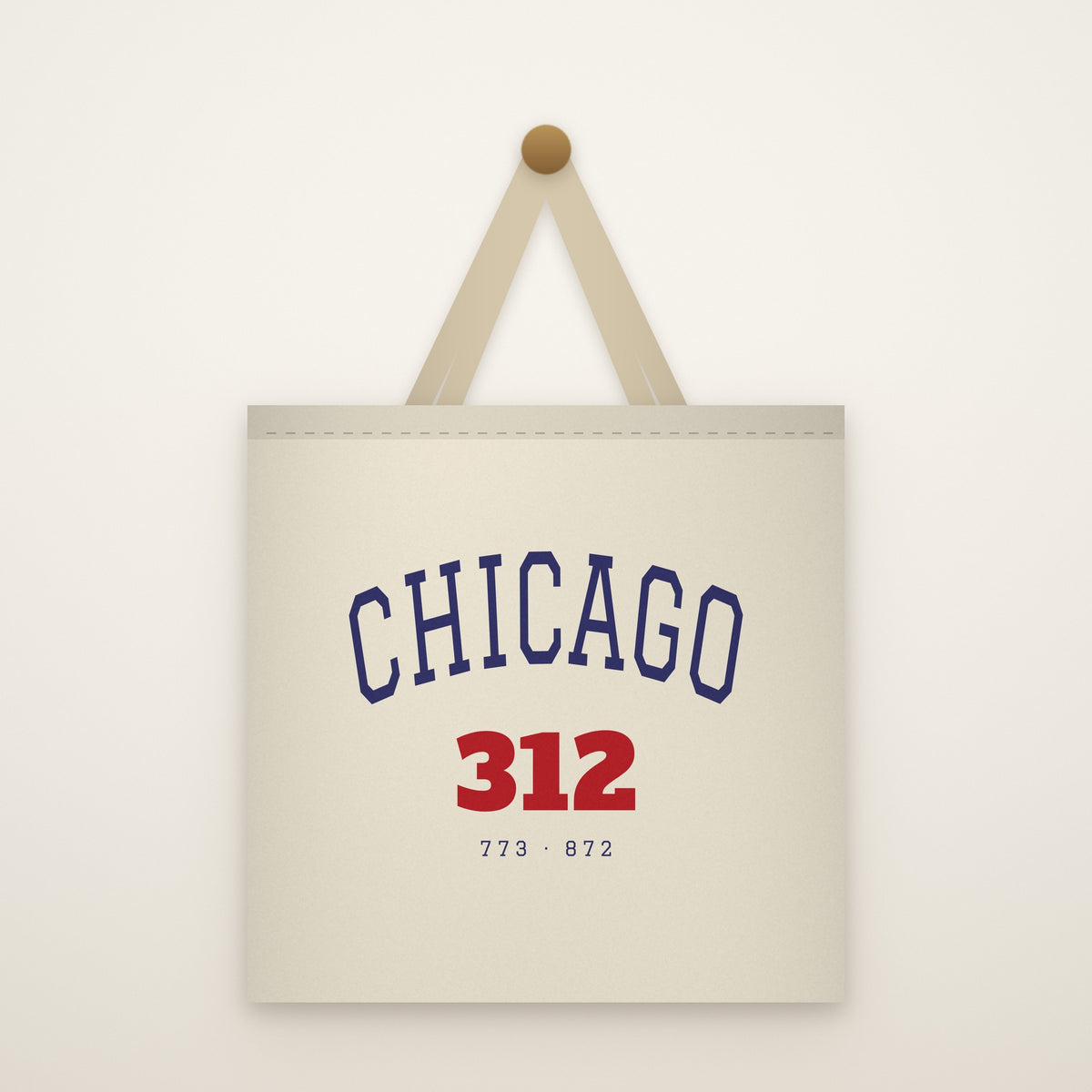 Chicago 312 Canvas Tote Bag hanging from a brass peg on an ivory wall