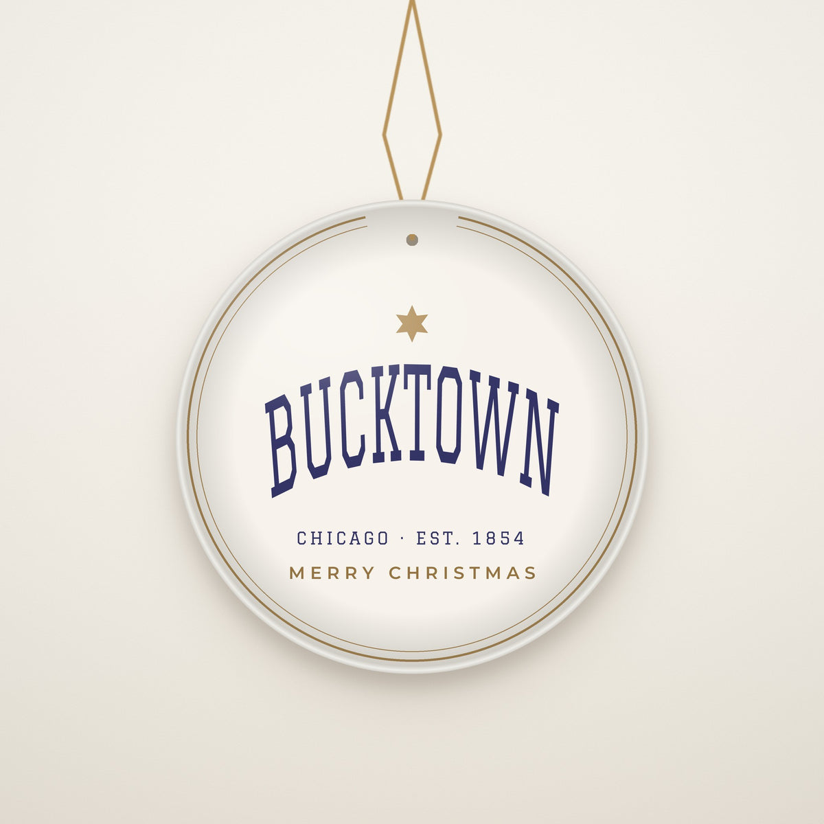 Bucktown Chicago Christmas Ornament, Est. 1854 hanging on a gold cord, ivory backdrop