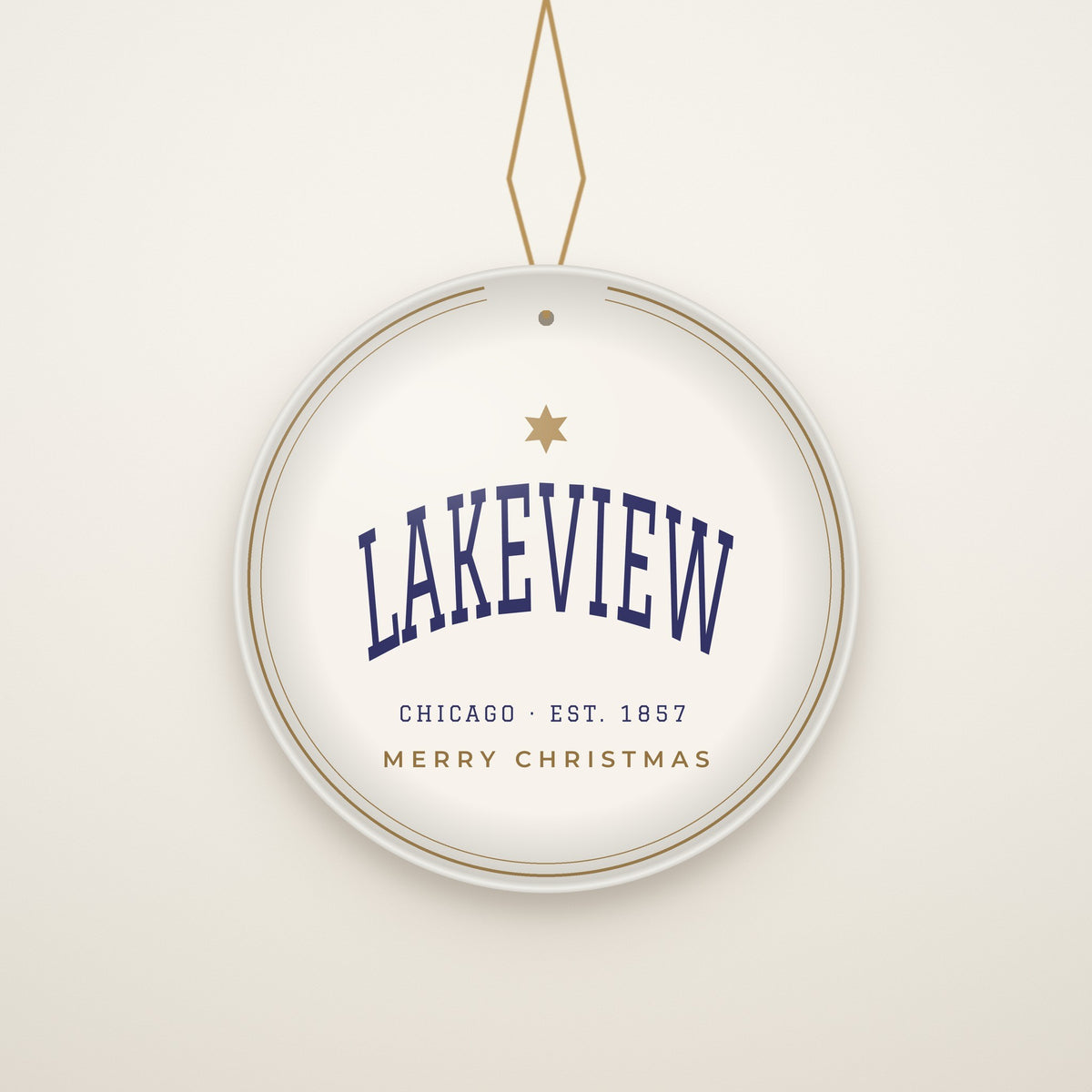 Lakeview Chicago Christmas Ornament, Est. 1857 hanging on a gold cord, ivory backdrop