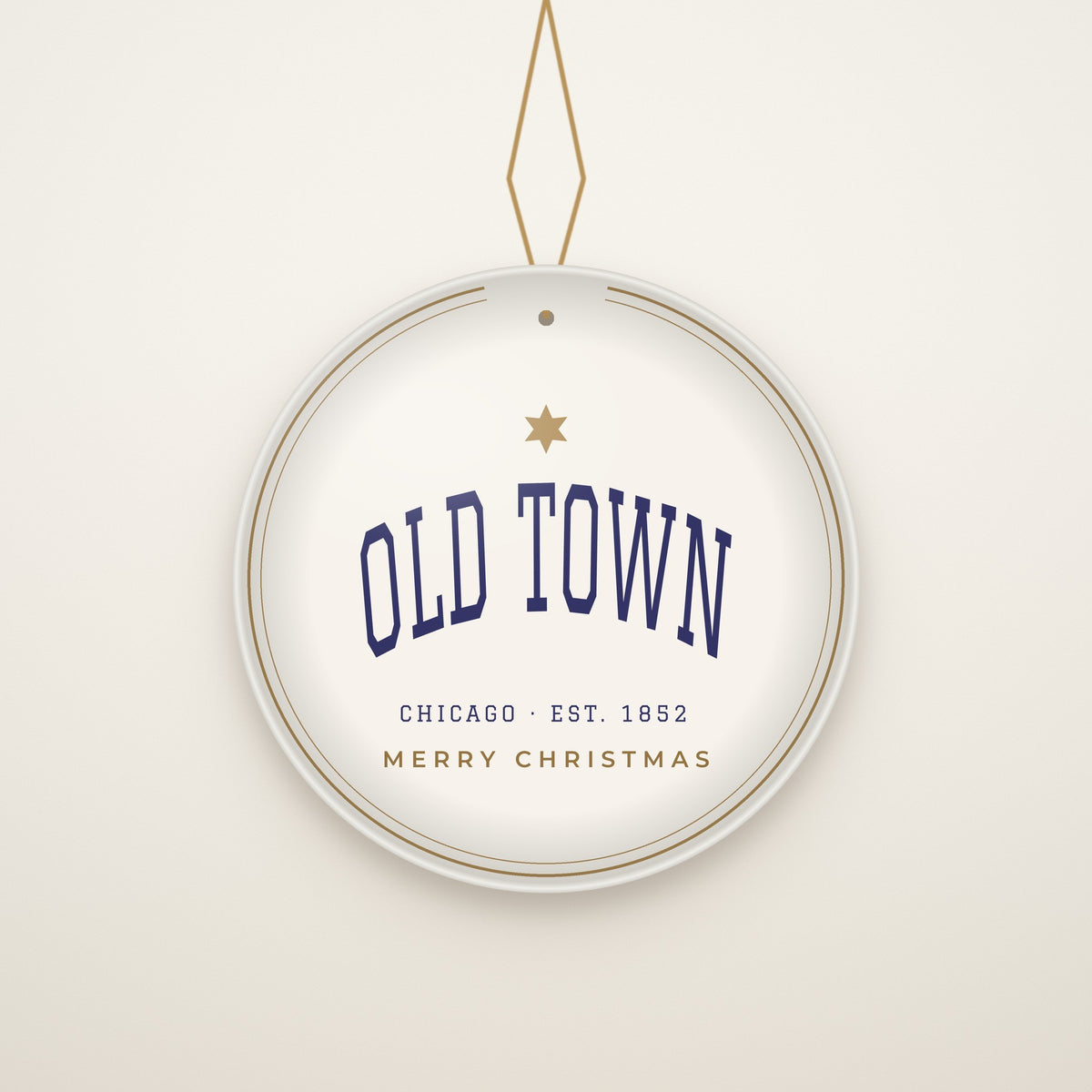 Old Town Chicago Christmas Ornament, Est. 1852 hanging on a gold cord, ivory backdrop