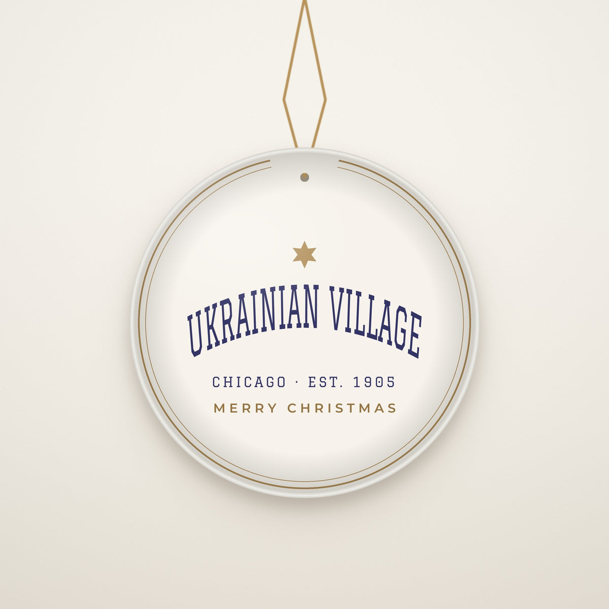 Ukrainian Village Chicago Christmas Ornament, Est. 1905 hanging on a gold cord, ivory backdrop