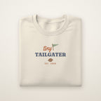 Tiny Tailgater Toddler Crewneck — Est. 2026 in Natural Heather, flat lay on ivory