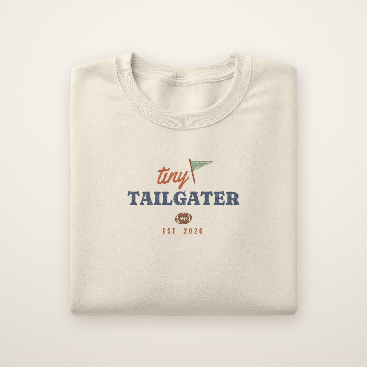 Tiny Tailgater Toddler Crewneck — Est. 2026 in Natural Heather, flat lay on ivory